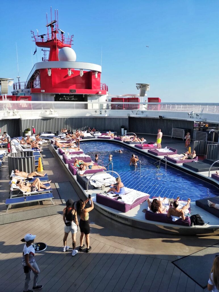a swimming pool on a cruise ship with people on day beds