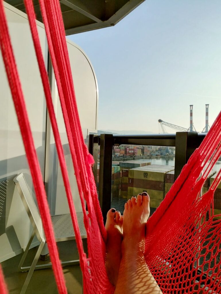 feet with painted toenails in a red hammock