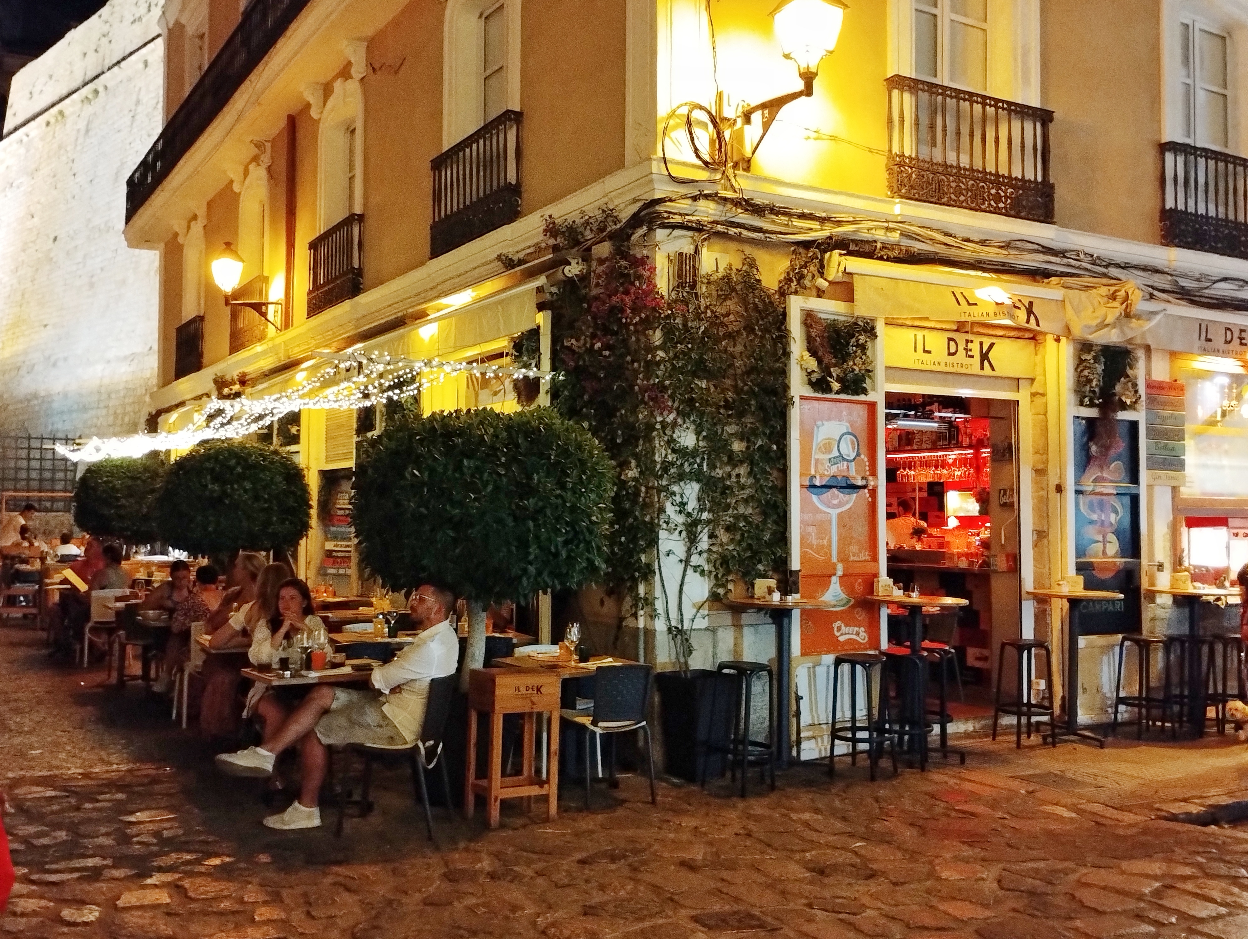 people seated outside of a well lit bar