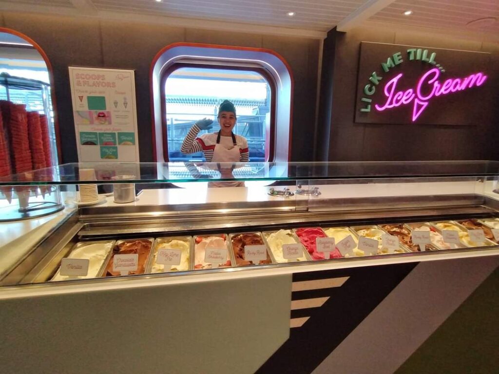 a lady waving at an ice cream stand