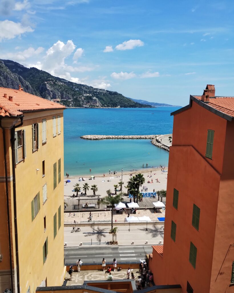 view of the sea between two colourful houses